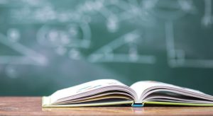 Imatge d'arxiu d'una pissarra i un llibre a un centre educatiu.