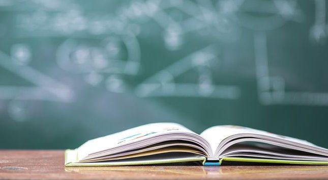 Imatge d'arxiu d'una pissarra i un llibre a un centre educatiu.