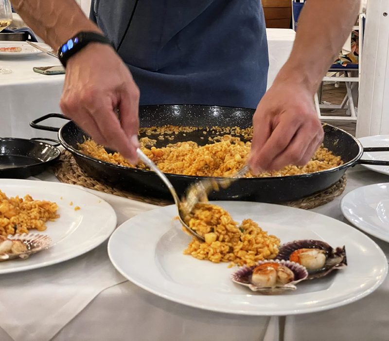 Cambrer servint paella a un restaurant.